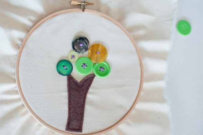 Embroidered circle of a tree with buttons as leaves -- teaching kids sewing