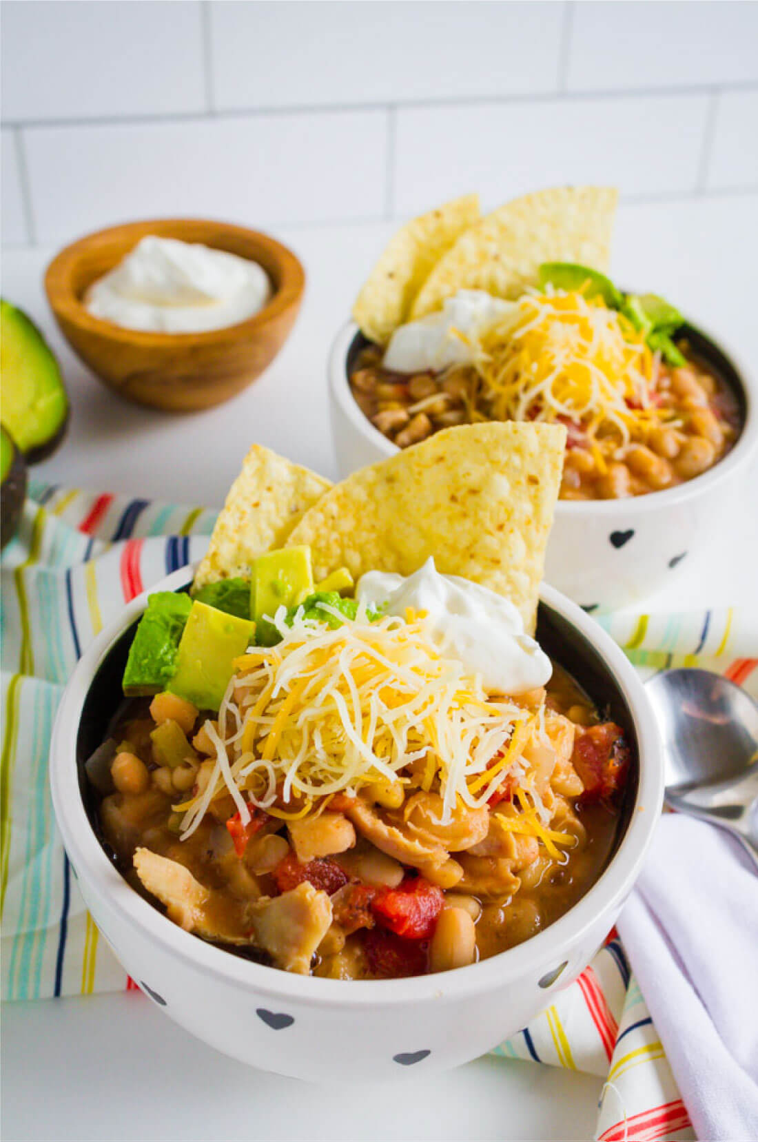 Slow Cooker White Bean Chicken Chili Recipe - a healthy recipe that your whole family will love. Shown with all of the toppings. 