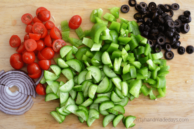 Chop vegetables for greek pasta salad dressing