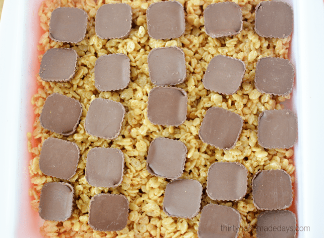 Layer Butterfinger Peanut Butter Cups on Rice Crispy Treats