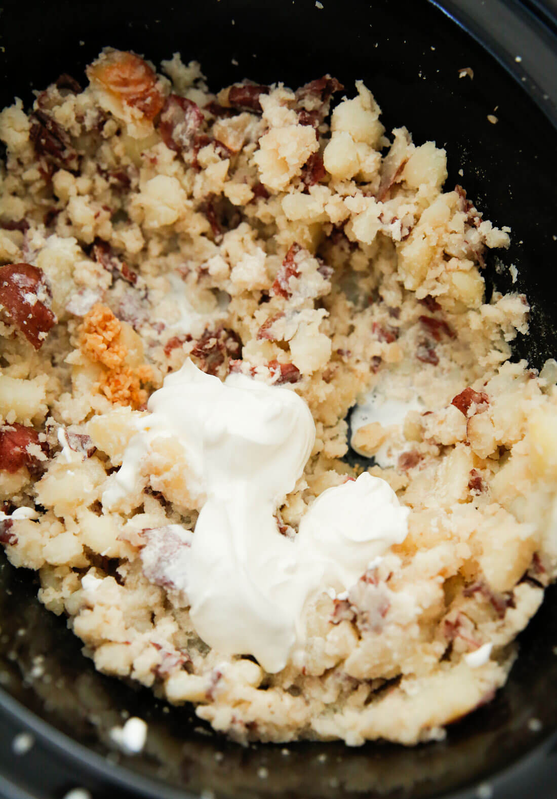 Crockpot Mashed Potatoes - make the most delicious mashed potato recipe you've ever had. Mashing the potatoes with other ingredients. 