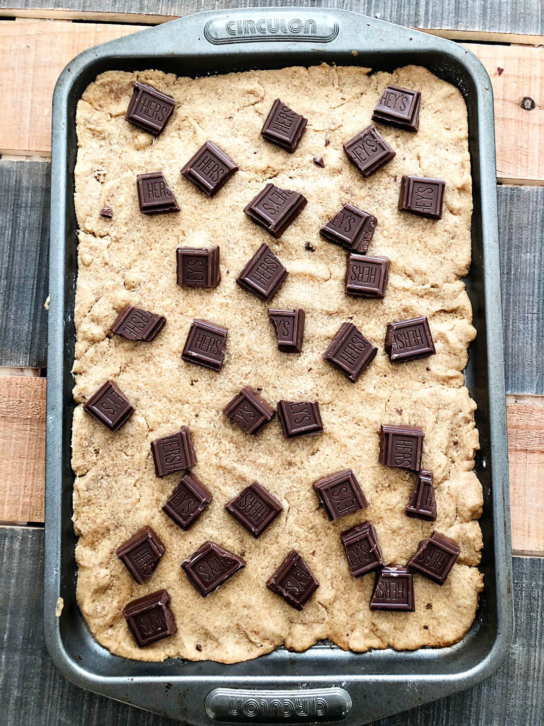 After baking the cookie on a cookie sheet, add broken up Hershey bars on top. 