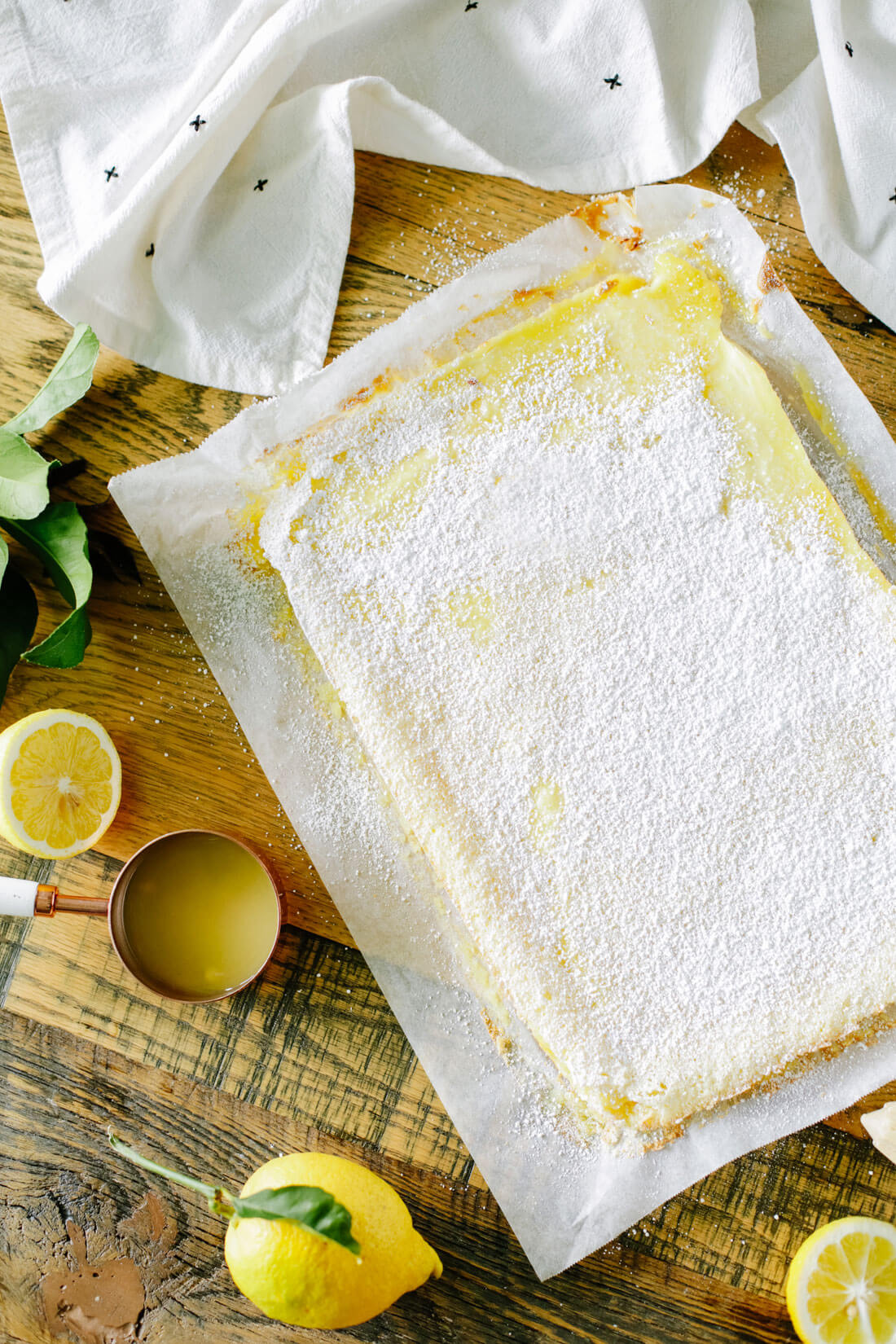 Lemon Bars - full sheet of bars with lemons surrounding them